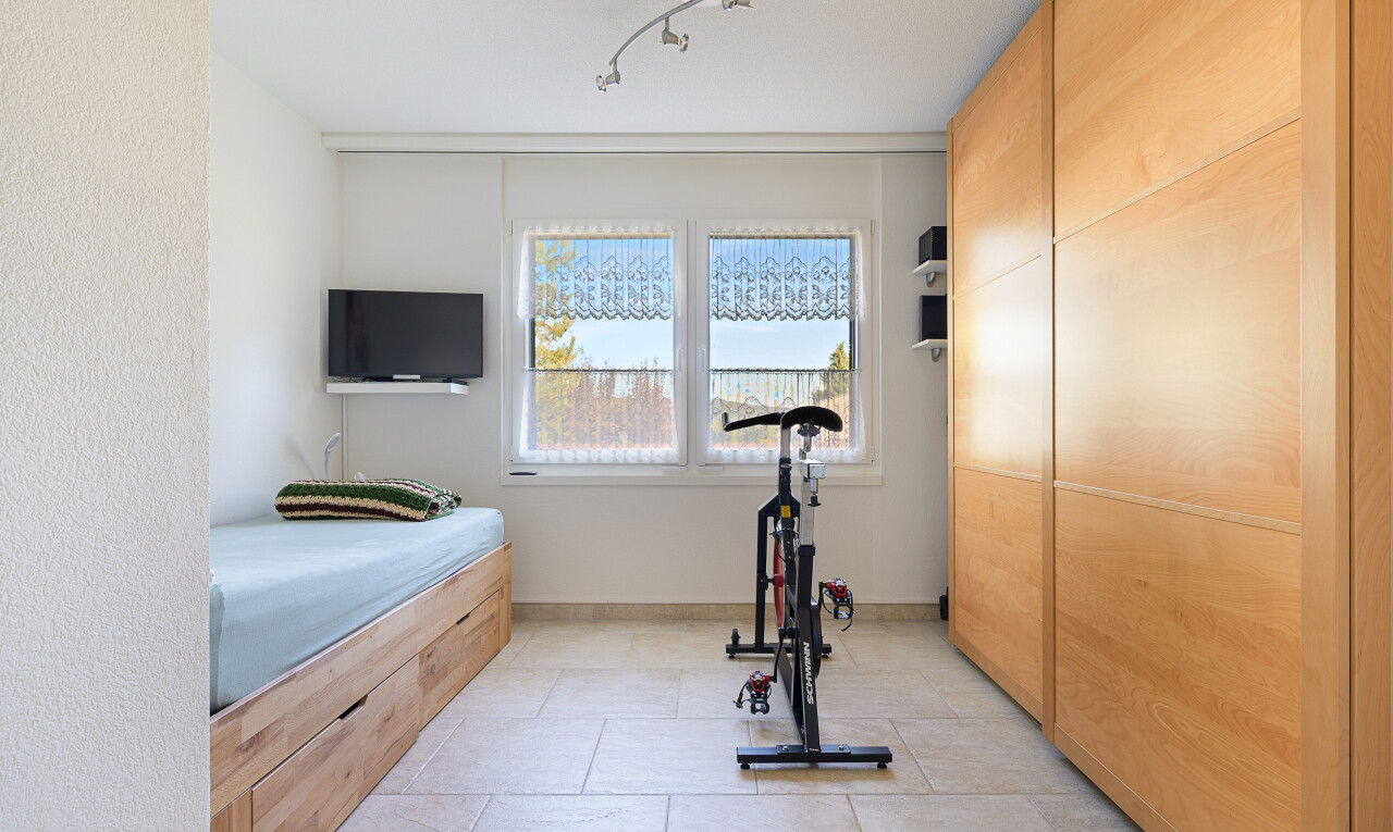 zimmer / schlafzimmer mit fernseher, natürliches licht, natural light, inside property, und fliesenboden