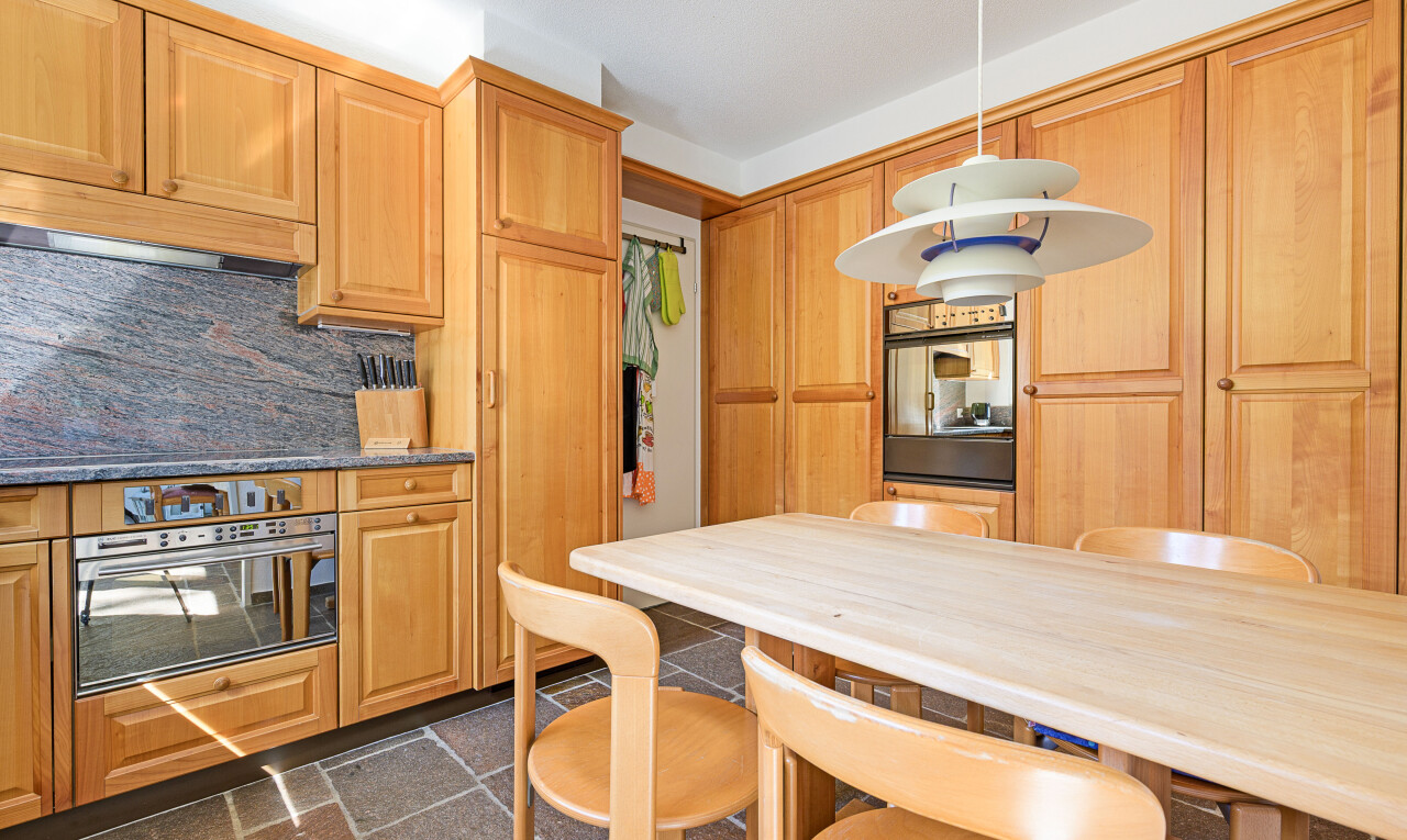 küche mit hochgezogene schränke, inside property, ofen, pendelleuchte, und küchenrückwand beim Herd