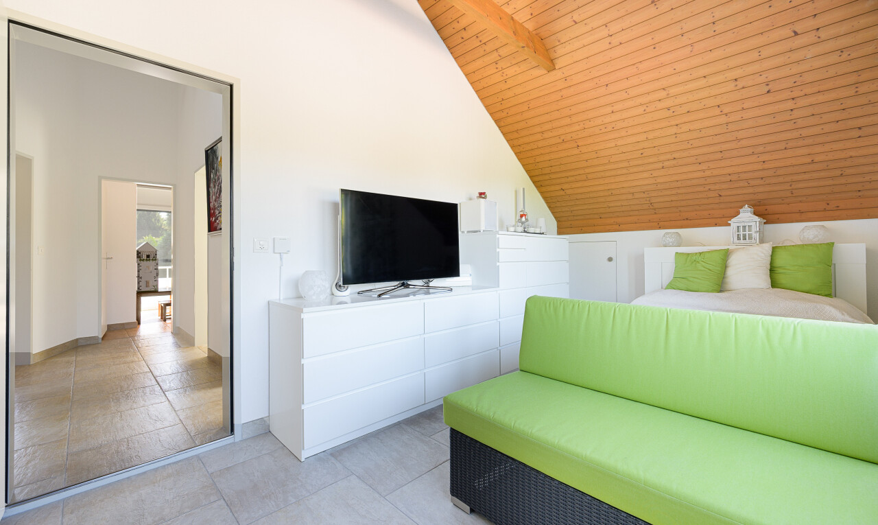 wohnzimmer mit fernseher, vaulted ceiling, dachschräge, drywall, und gipskartonwand