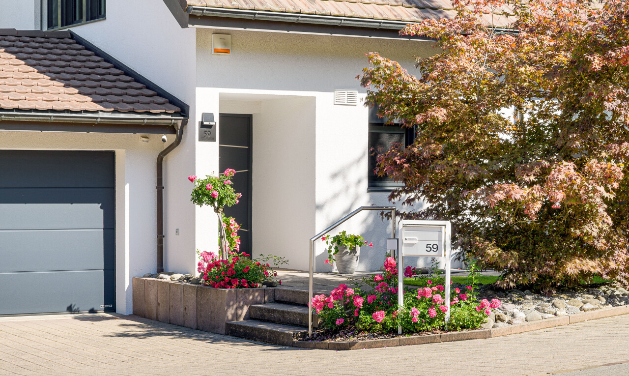 außenansicht mit property visible, ziegeldach, garage angeschlossen, und stuckverkleidung