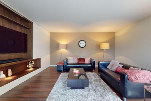 wohnzimmer mit fernseher und parkettboden