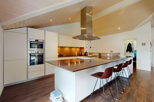 küche mit doppel backofen, parkettboden, dunstabzugshaube, dachschräge, und weiße schränke