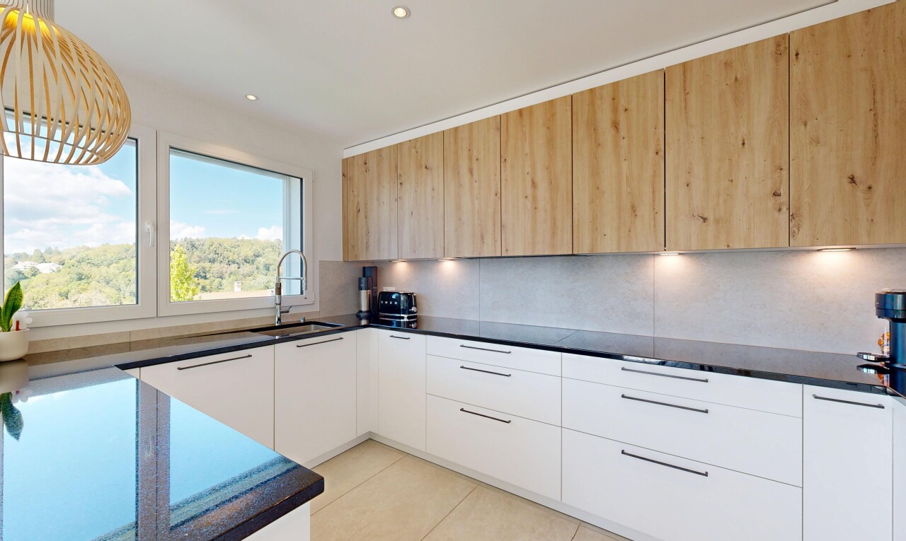 cuisine avec dark countertops, flat panel cabinets, armoires à panneau plat, two tone kitchen, et day time