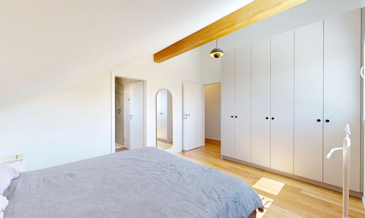 chambre avec wood finish floor, sol en finition bois, placard, beamed ceiling, et plafond à poutres