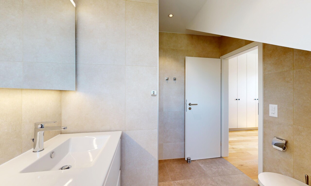 salle de bains avec tile wall, mur en carrelage, évier, light floor, et inside property