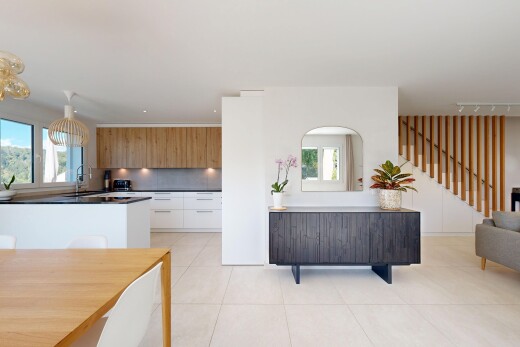 cuisine avec escaliers, flat panel cabinets, armoires à panneau plat, light floor, et dark countertops
