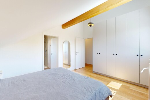chambre avec wood finish floor, sol en finition bois, placard, beamed ceiling, et plafond à poutres