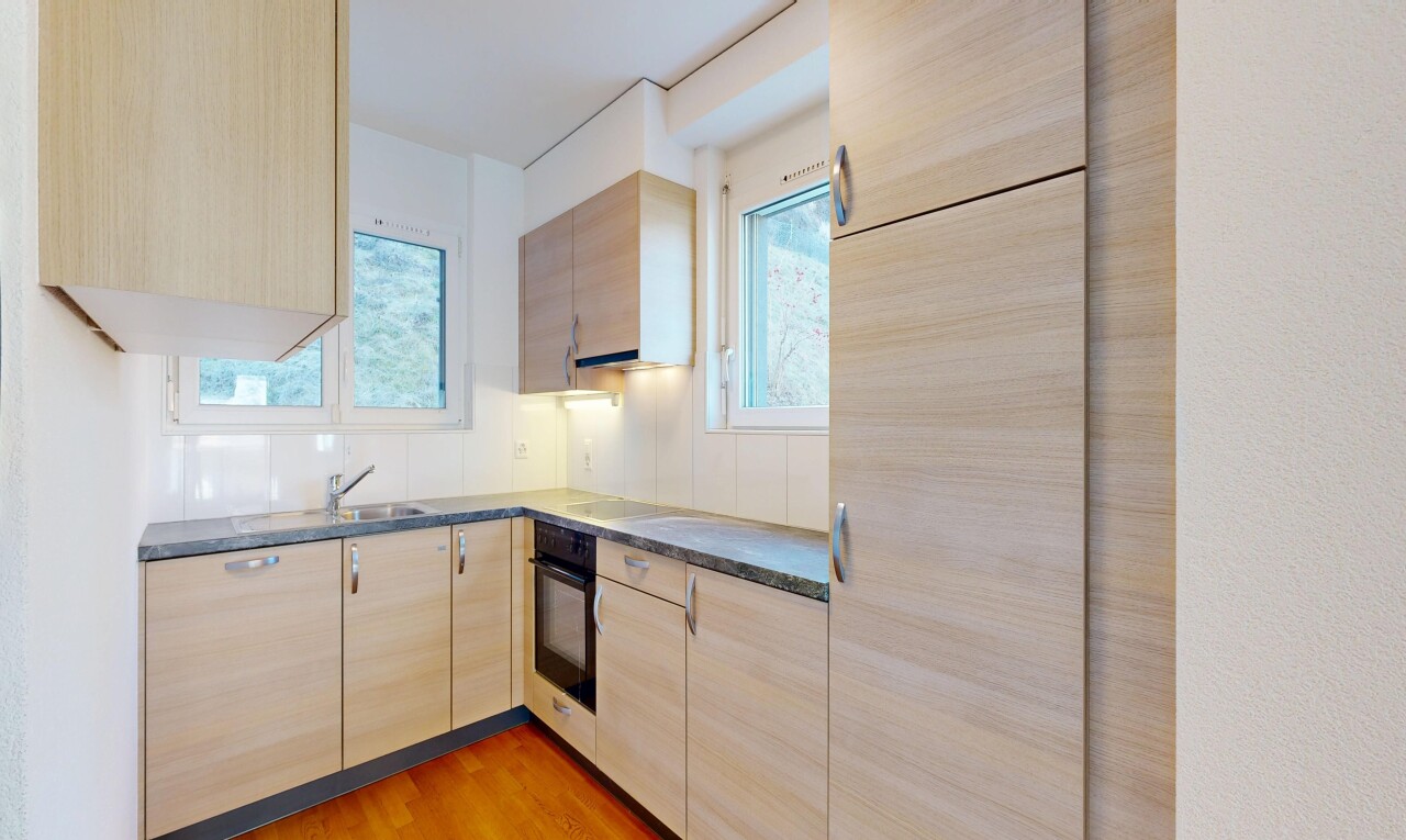 cuisine avec armoires marron clair, light brown cabinets, wood finish floor, sol en finition bois, et plans de travail
