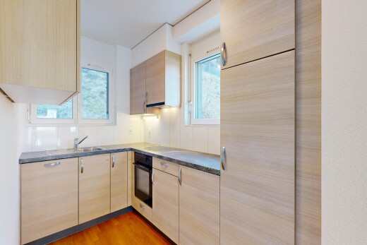 cuisine avec armoires marron clair, light brown cabinets, wood finish floor, sol en finition bois, et plans de travail