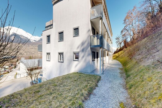 view of property with a balcony, stucco siding, a mountain view, and a patio