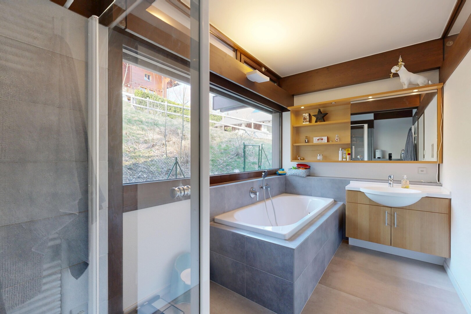 salle de bains avec miroir, natural light, lumière naturelle, light floor, et lavabo (ou coiffeuse selon le contexte)