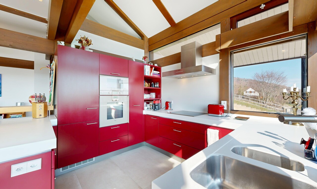cuisine avec inside property, hotte, four, armoires rouges, et red cabinets
