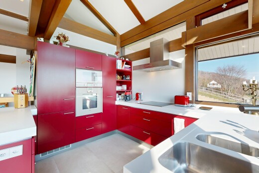 cuisine avec inside property, hotte, four, armoires rouges, et red cabinets