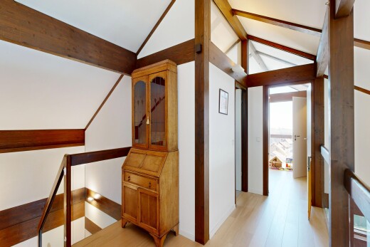 couloir avec palier à l'étage, plafond voûté, vaulted ceiling, sol en finition bois, et wood finish floor