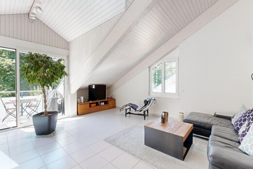 living area featuring light tile patterned floors and beamed ceiling