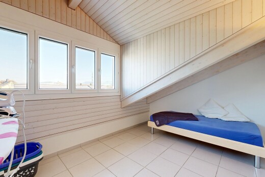 room featuring lofted ceiling, light tile patterned flooring, and wooden walls