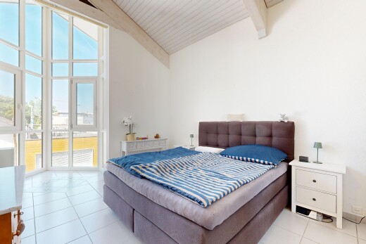 room with light tile patterned floors and a high wooden beamed ceiling