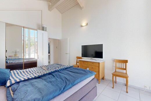 room / bedroom with lofted ceiling, light tile patterned flooring, and a closet