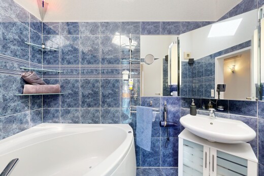 full bath featuring tile walls, vanity, and a garden tub
