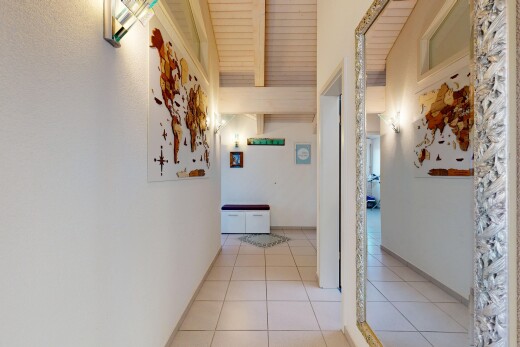 hall with beam ceiling and light tile patterned floors
