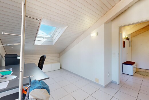 office area with lofted ceiling with skylight and light tile patterned floors