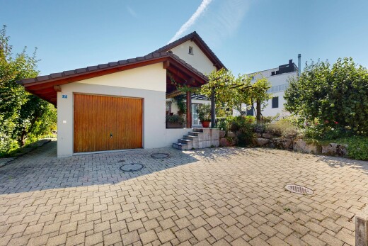 außenansicht mit terrasse, day time, garage angeschlossen, property visible, und stuckverkleidung