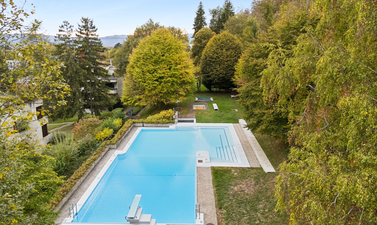 swimming pool with a diving board, a patio area, and a yard