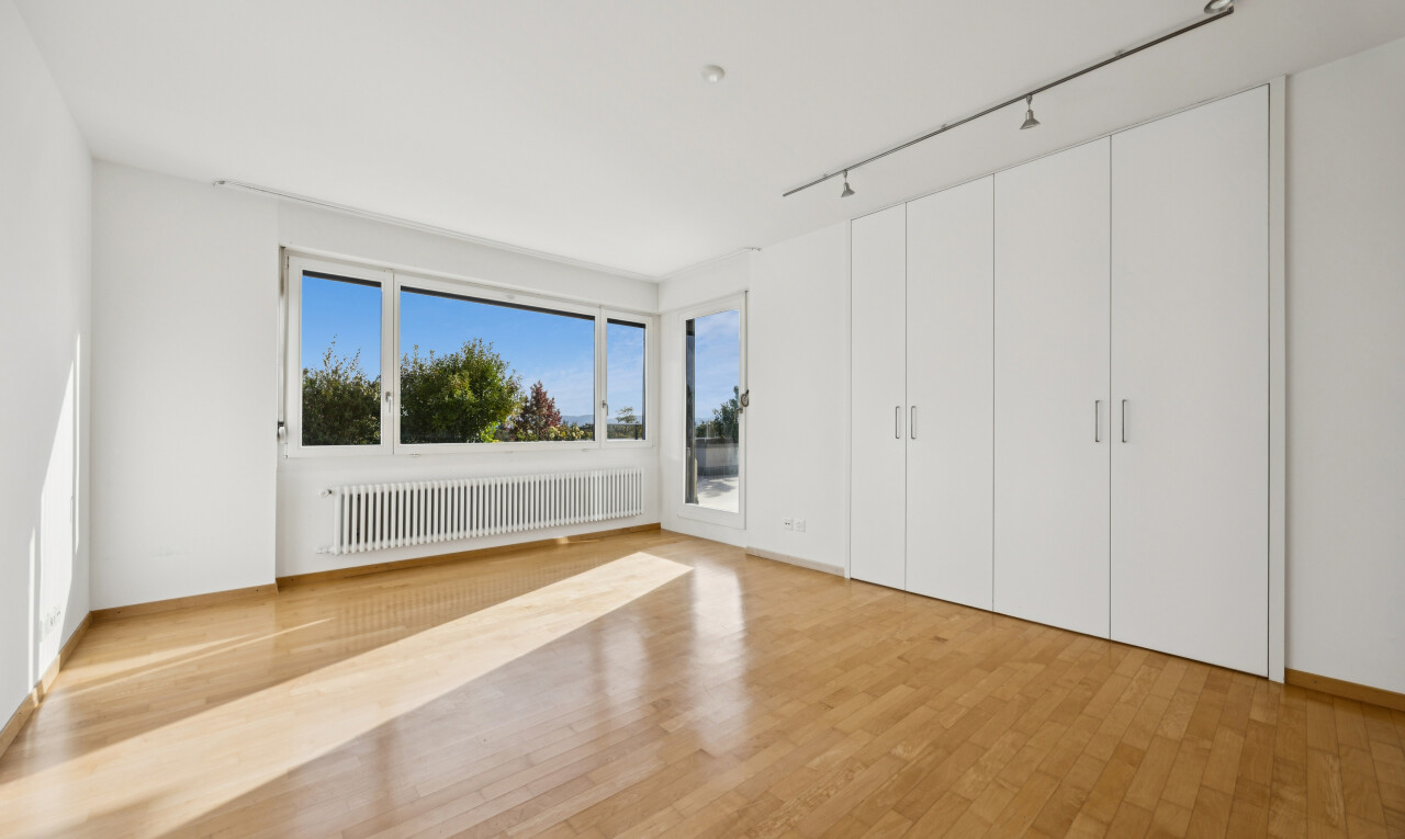 unfurnished room featuring radiator, light wood finished floors, and rail lighting
