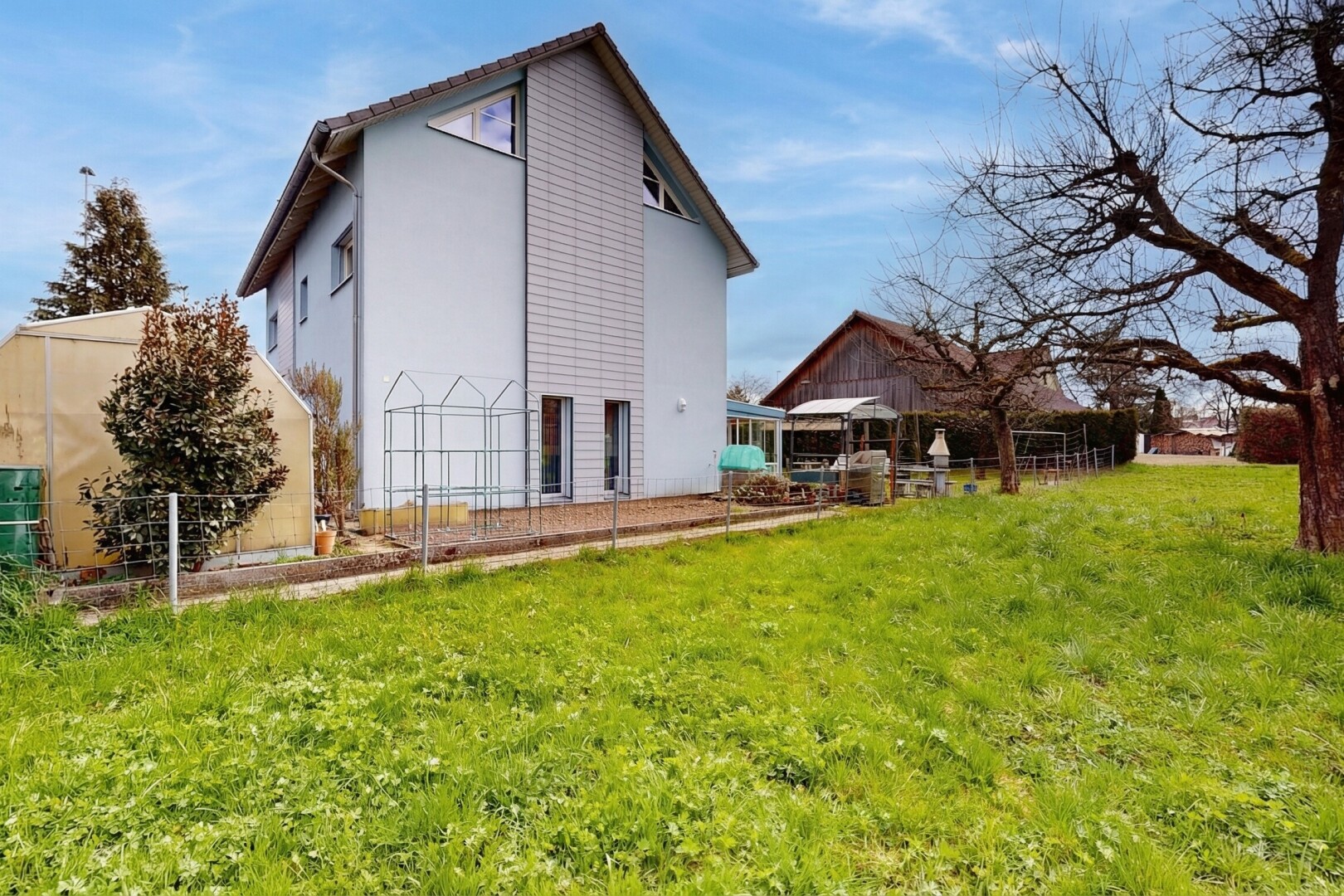 façade avec property visible, pelouse, day time, bardage en stuc, et structure extérieure