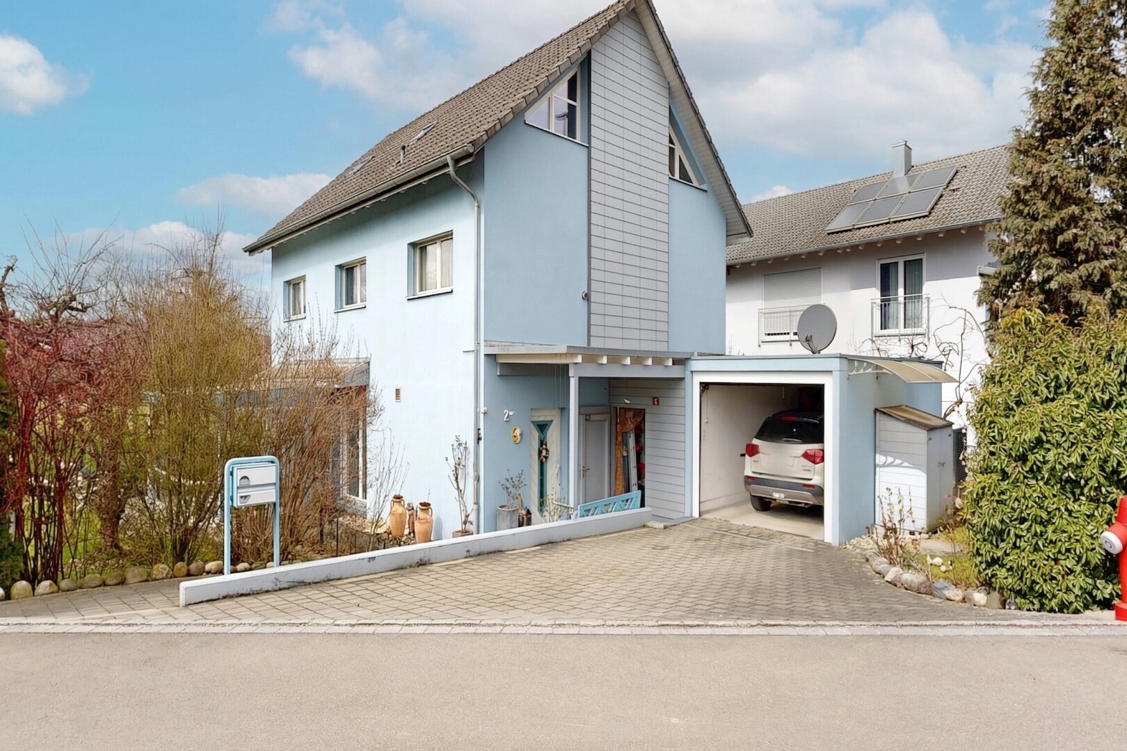 façade avec property visible, day time, bardage en stuc, et allée