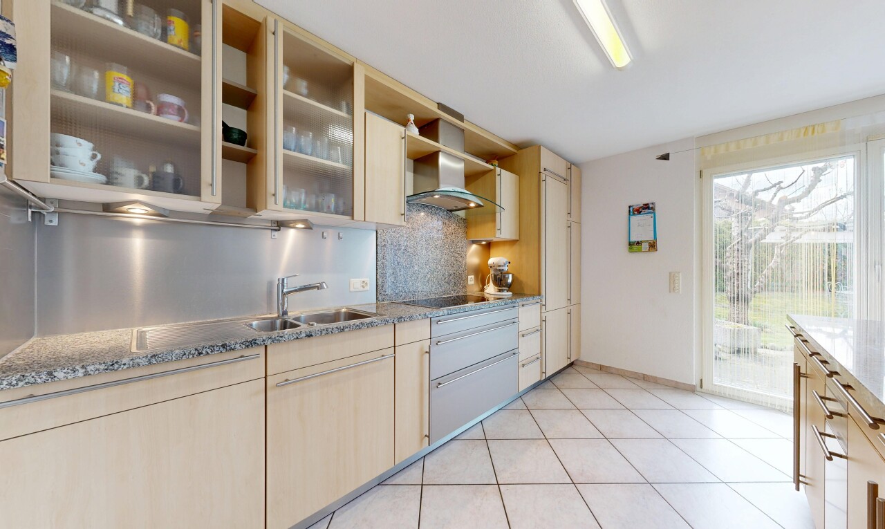 cuisine avec light brown cabinets, armoires marron clair, light floor, hotte, et backsplash