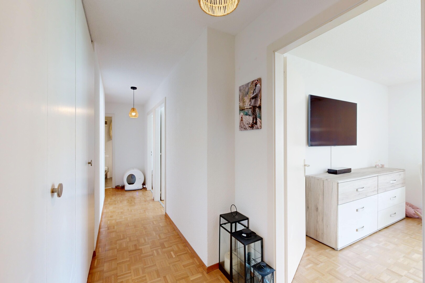 couloir avec parquet floor, télévision, sol en finition bois, wood finish floor, et light floor