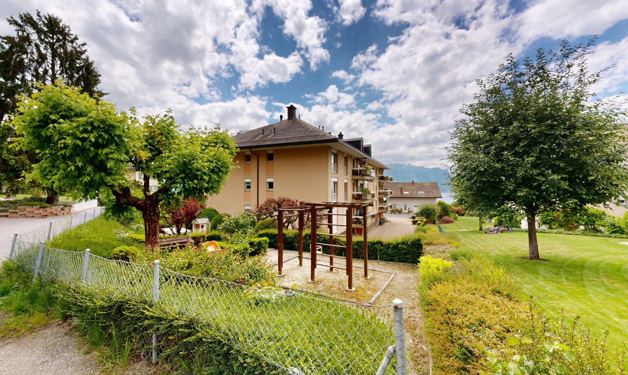 façade avec pergola, pelouse, bardage en stuc, day time, et property visible