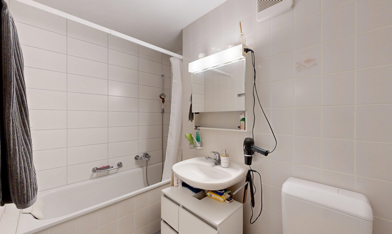 salle de bains avec salle de bain complète, tile wall, mur en carrelage, évier, et inside property