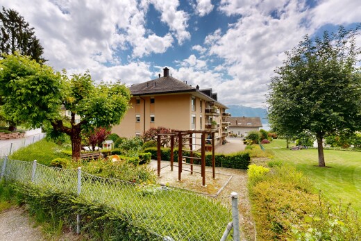 façade avec pergola, pelouse, bardage en stuc, day time, et property visible