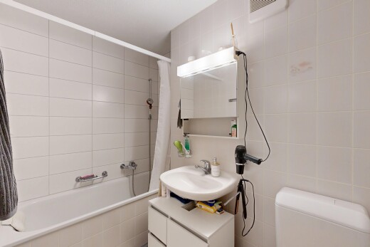 salle de bains avec salle de bain complète, tile wall, mur en carrelage, évier, et inside property