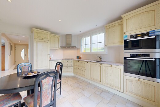 küche mit doppel backofen, bogenförmige schränke, inside property, dunstabzugshaube, und arbeitsplatten