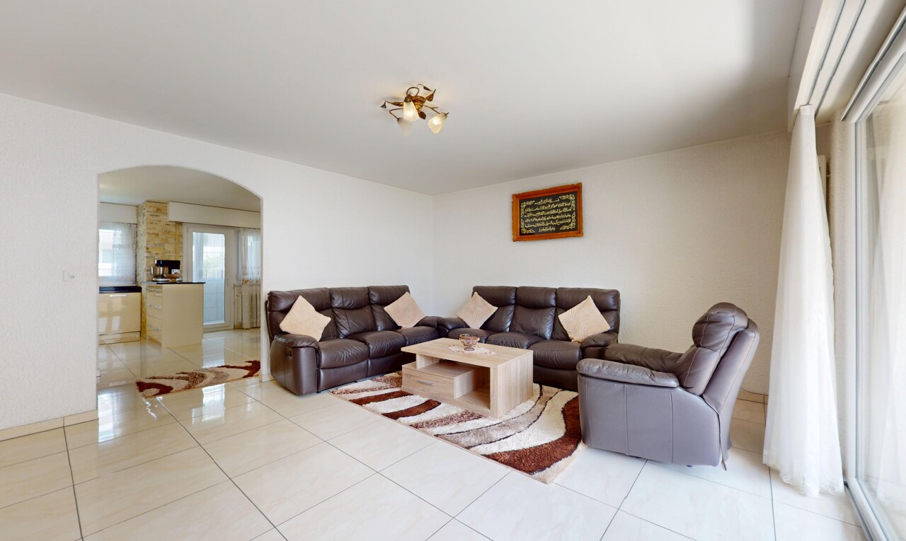 wohnzimmer mit gewölbte gehwege, gipskartonwand, drywall, fliesenboden, und tile floor