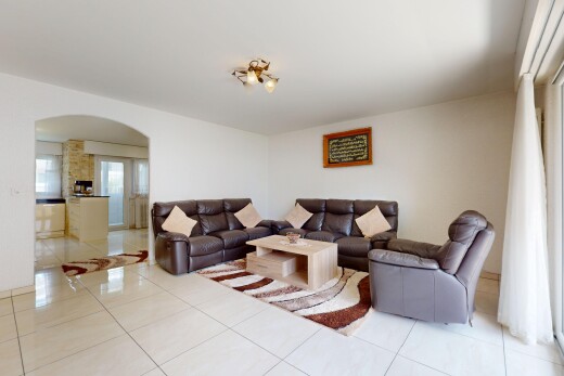 living room featuring arched walkways and tile patterned floors