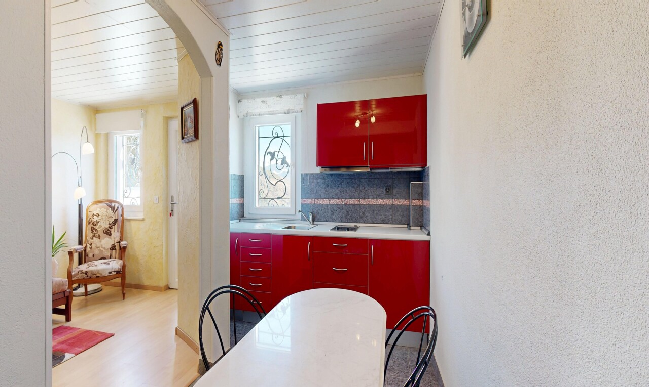 cuisine avec red cabinets, armoires rouges, natural light, lumière naturelle, et backsplash