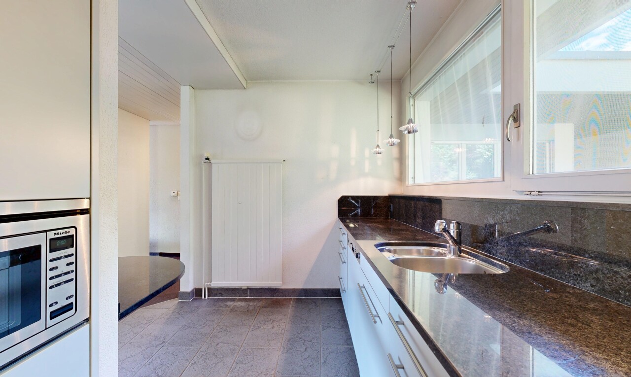 küche mit dark countertops, waschbecken, pendant lighting, mikrowelle, und drywall