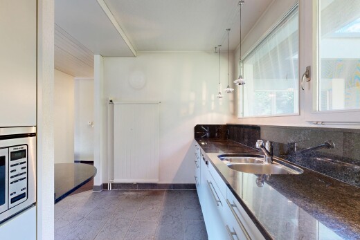 kitchen with stainless steel microwave, dark stone countertops, and white cabinets