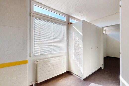 unfurnished room with radiator heating unit and dark carpet