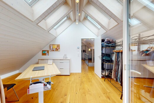 espace intérieur avec pièce supplémentaire, plafond à poutres, sol en finition bois, et puits de lumière