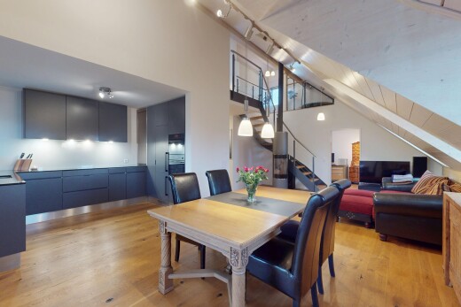 wohn- / esszimmer mit fernseher, gipskartonwand, hohe decke, holzfußboden, und treppen