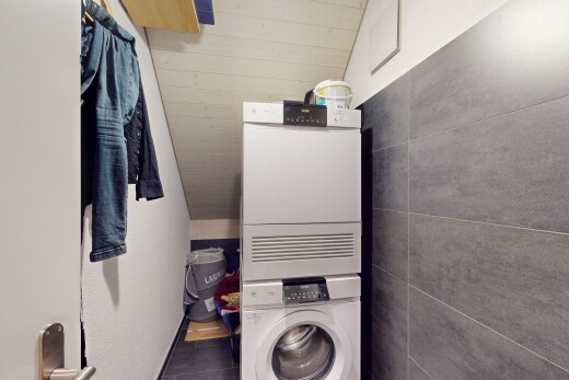 buanderie avec sol en carrelage, buanderie, et lave-linge et sèche-linge superposés