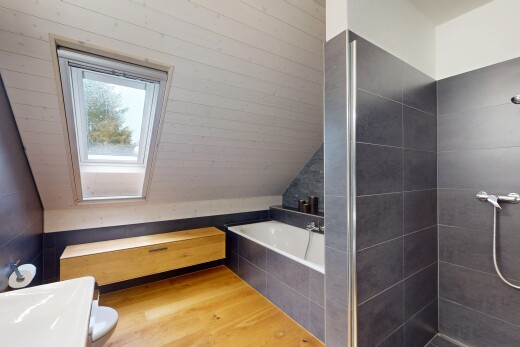 salle de bains avec plafond voûté, sol en finition bois, salle de bain complète, lumière naturelle, et douche