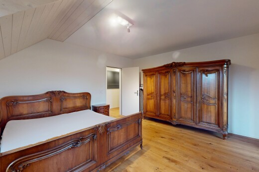 chambre avec plafond voûté, cloison sèche, et sol en finition bois