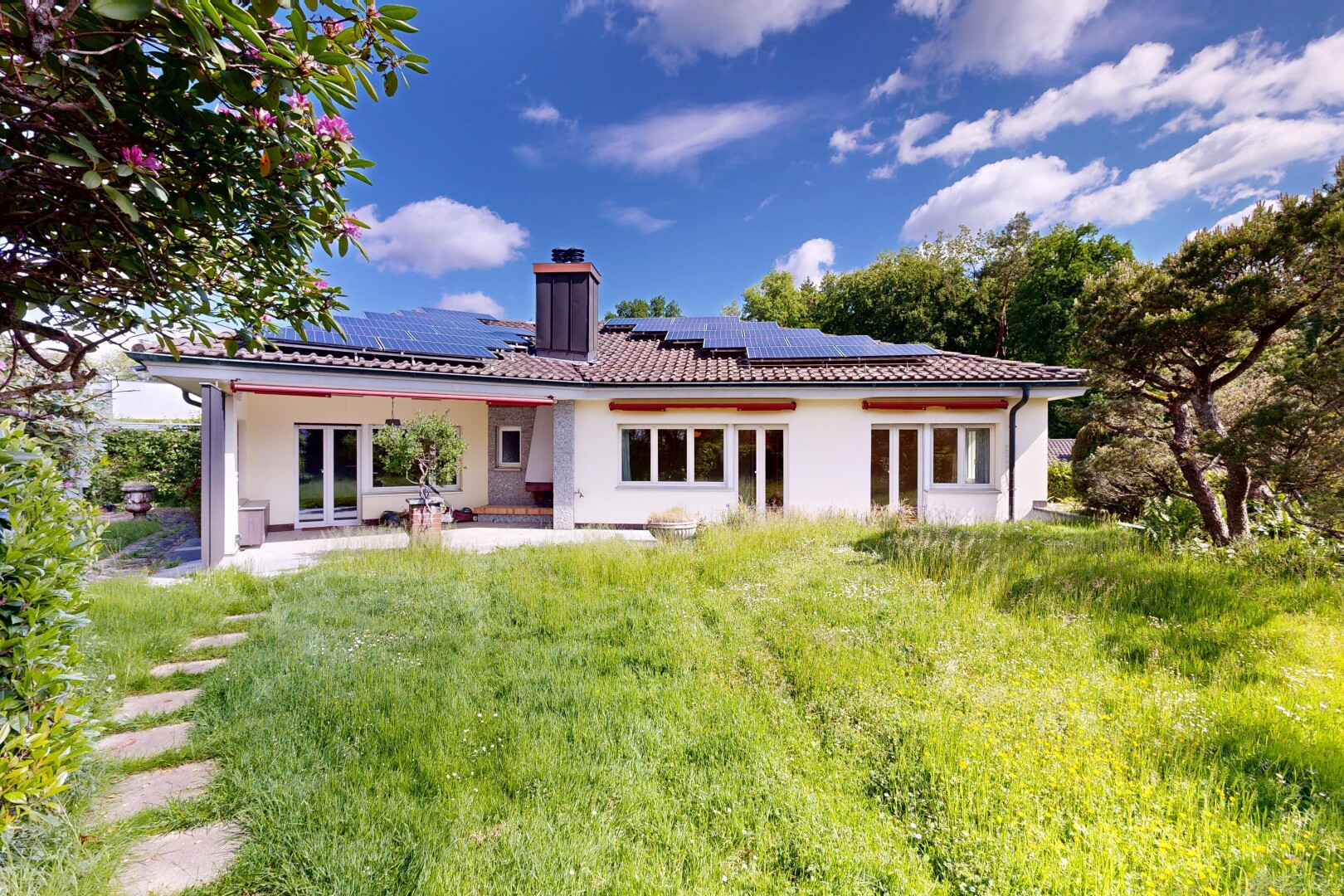 außenansicht mit property visible, schornstein, solaranlage, terrasse, und französische türen