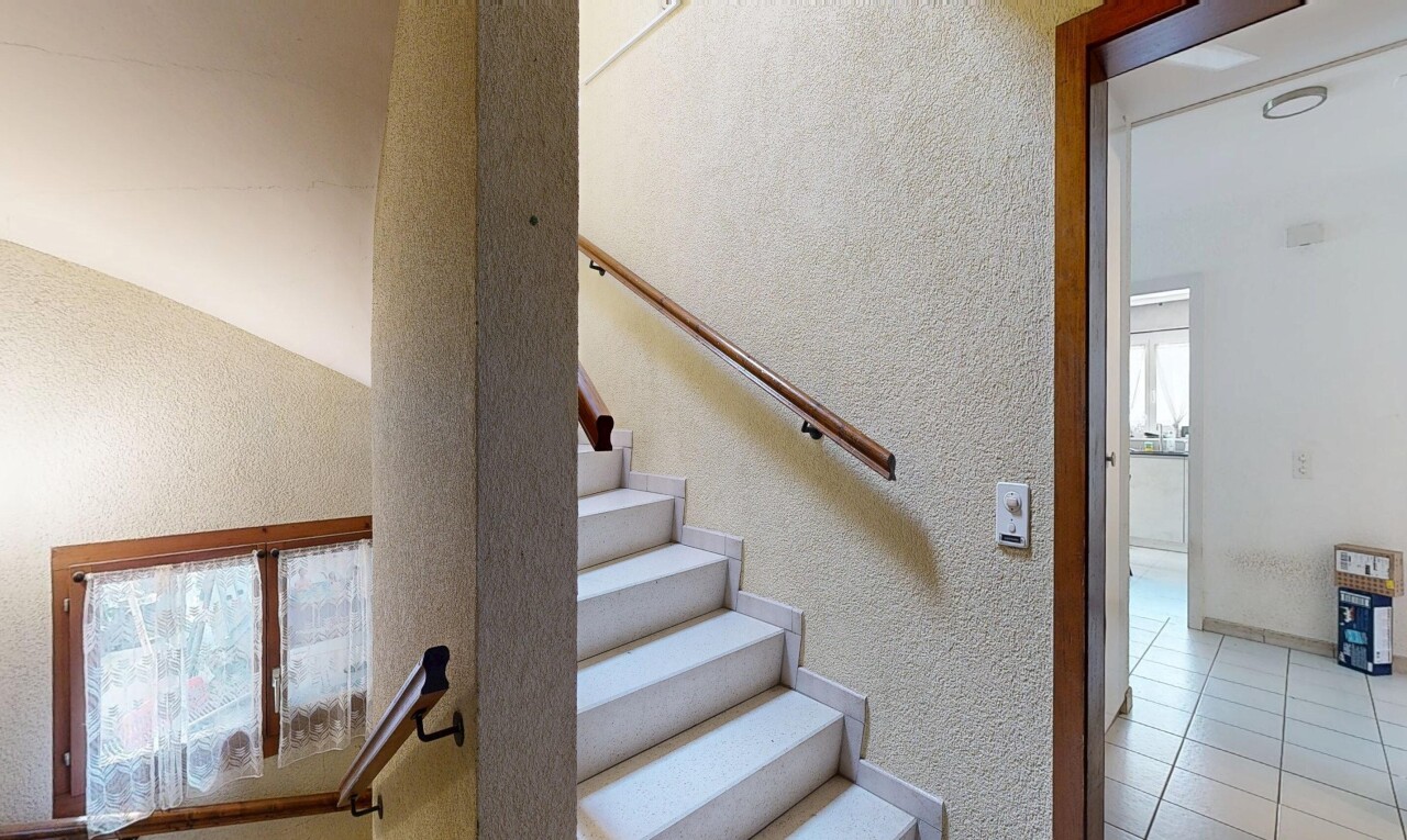 staircase featuring a textured wall and tile patterned floors